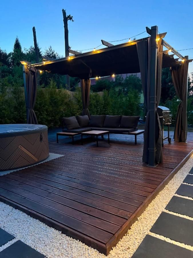 Jacuzzi na tarasie pod pergolą z lampkami