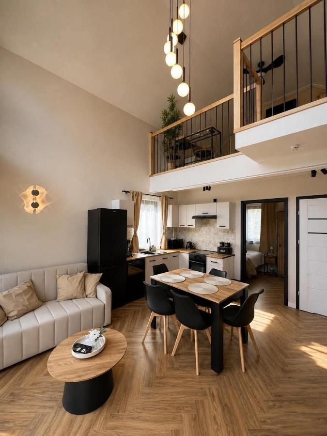 Jasny salon z kanapą, kuchnią, stołem i antresolą